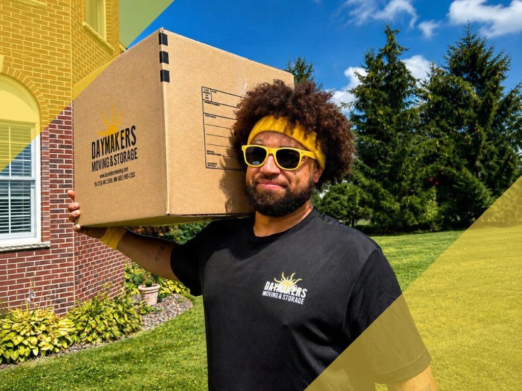 Daymakers crew member carrying a labelled moving box