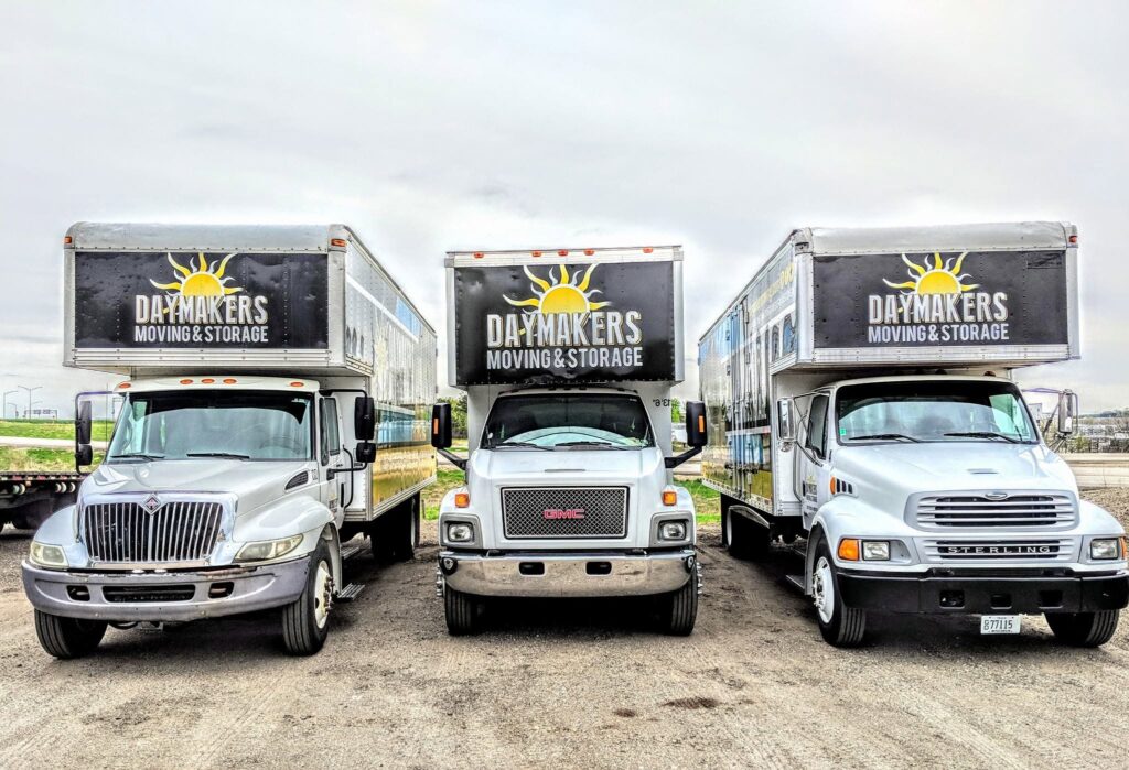 Three Daymakers Moving & Storage trucks parked side by side
